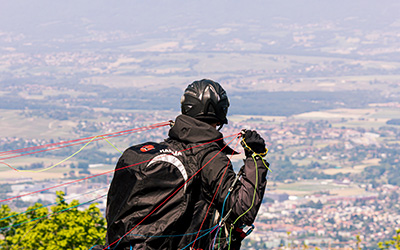 Persona contemplando una vista panoramica mientras se prepara para lanzarse en parapente.