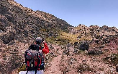 Persona fotografiando el paisaje de Los Gigantes durante un trekking de Nativo Viajes en Córdoba, Argentina.