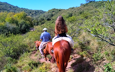 Personas cabalgando por los senderos de las colinas de Candonga, Córdoba, Argentina.