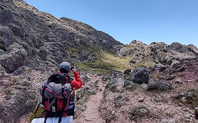 Persona fotografiando la vista de Los Gigantes durante el trekking organizado por Nativo Viajes.